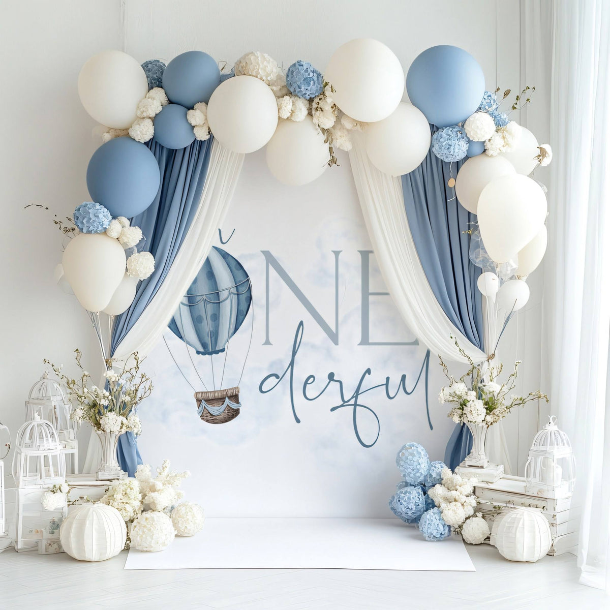 Mr Onederful backdrop under a draped arch of blue and cream fabric and balloons.
