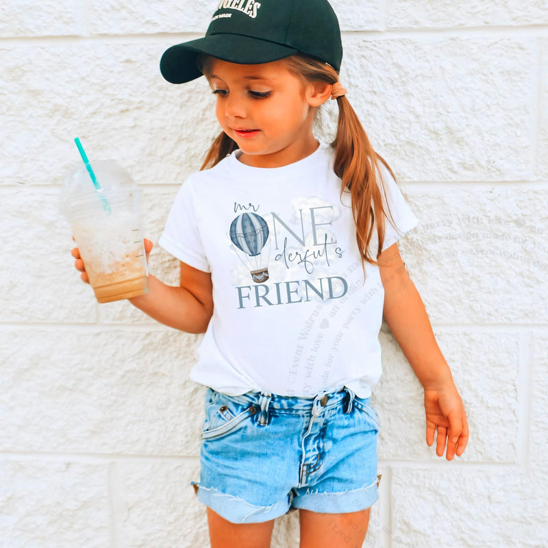 Girl in a ball cap holding a drink in a white Mr Onederful's Friend tee.