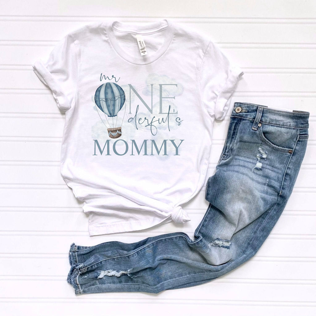 White Mr Onederful's Mommy adult tee laid flat beside ripped jeans.