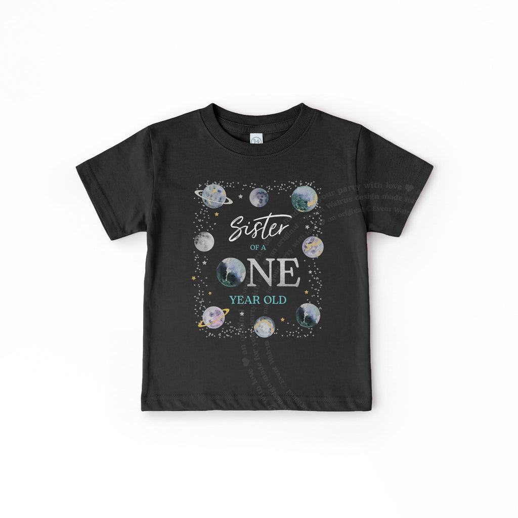 Black toddler Sister of a ONE Year Old tee with watercolor planets, laid flat.