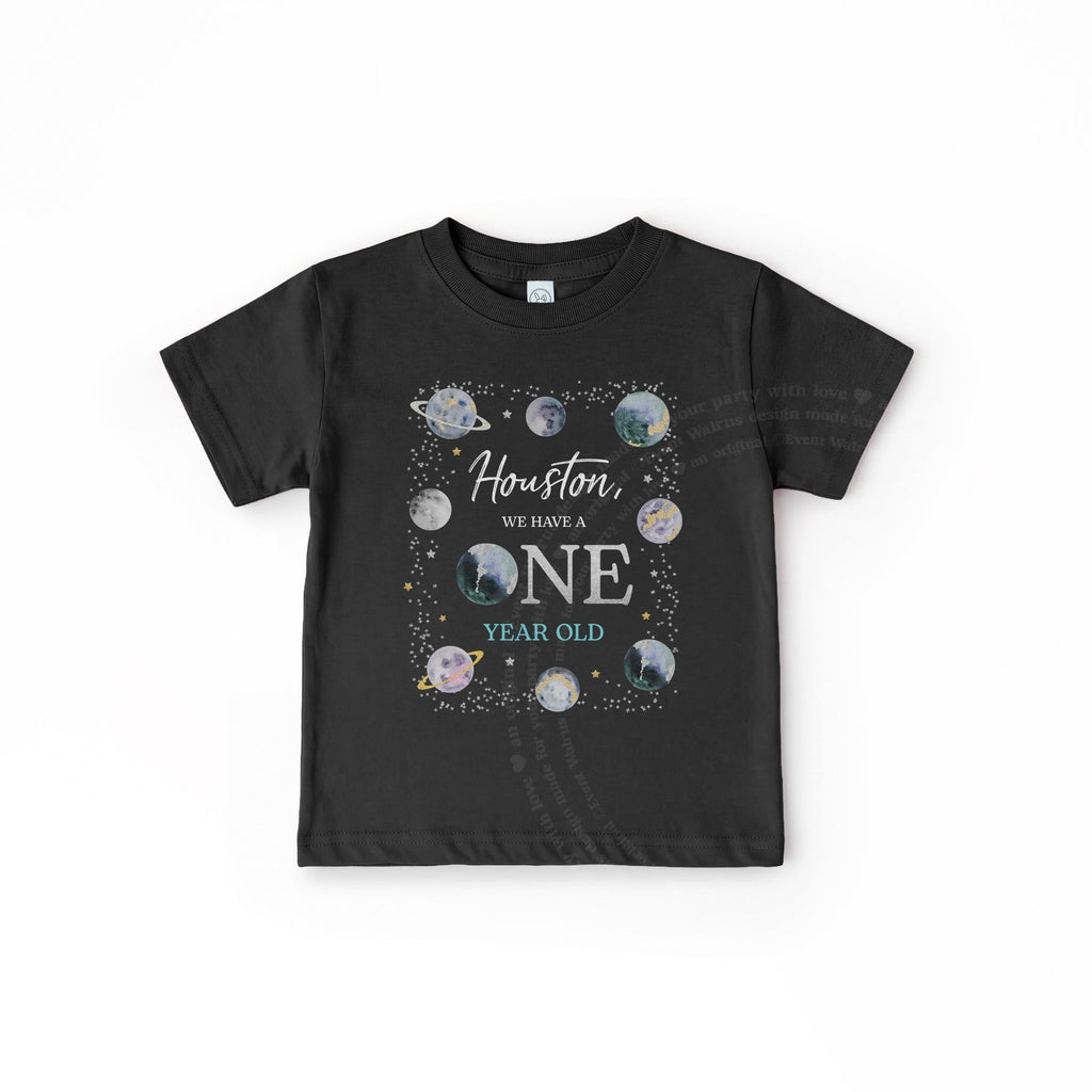 Black toddler Houston We Have a ONE Year Old tee with planets, laid flat.