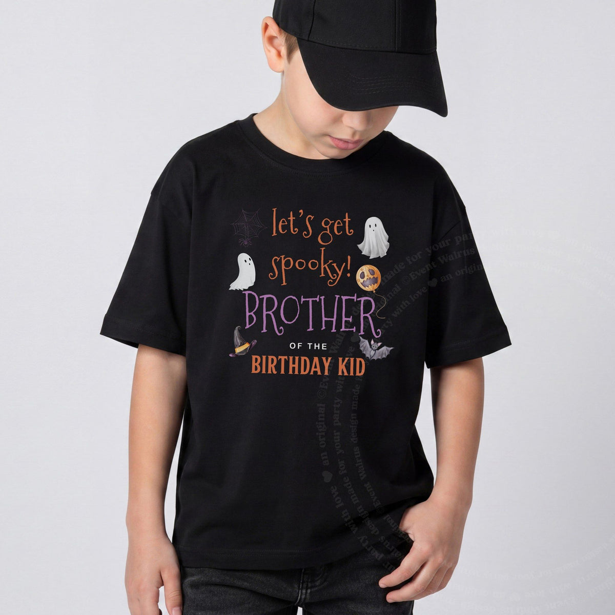 Boy in a black cap wearing a black Let's Get Spooky Brother of the Birthday Kid shirt.