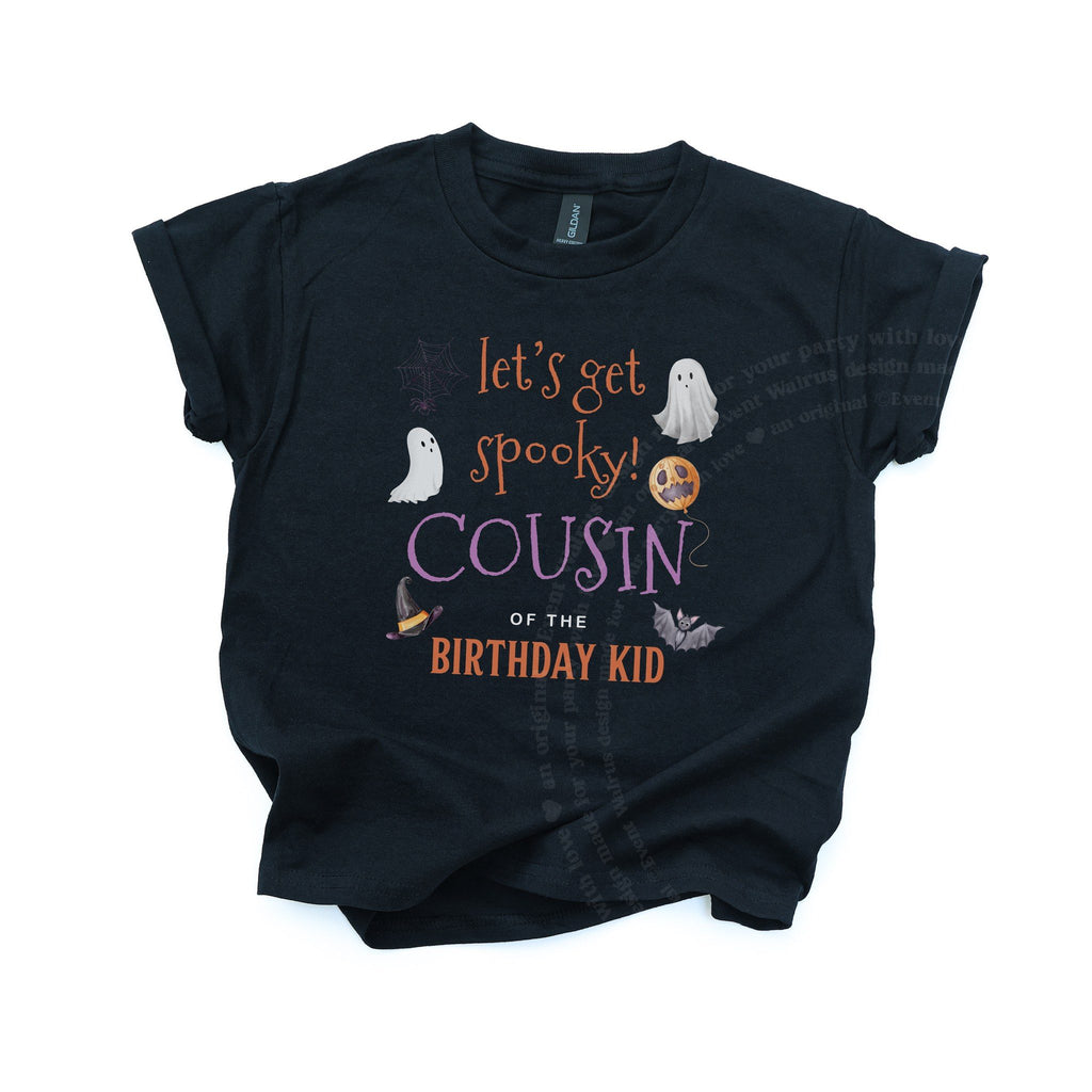Black kids Cousin of the Birthday Kid tee with ghosts and a witch hat, laid flat.