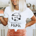Woman holding a mug in a white Let's Get Spooky Birthday Girl's Mama shirt.