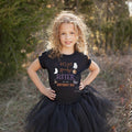 Curly haired girl in a black tutu wearing a Let's Get Spooky Sister of the Birthday Kid shirt.