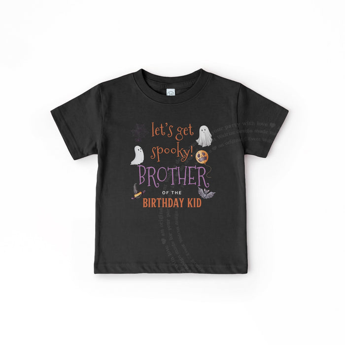 Toddler boy with a pacifier in a black Let's Get Spooky Brother of the Birthday Kid shirt.