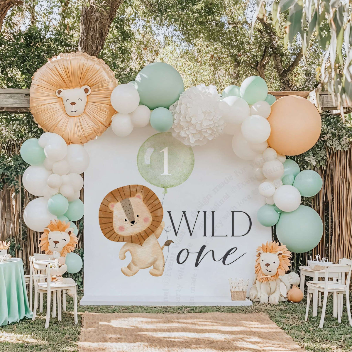 Watercolor lion Wild One backdrop framed by mint and peach balloons with a lion head balloon on top.