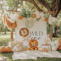Lion Wild One backdrop under a wooden pergola with a sage, cream and terracotta balloon garland and pampas grass.