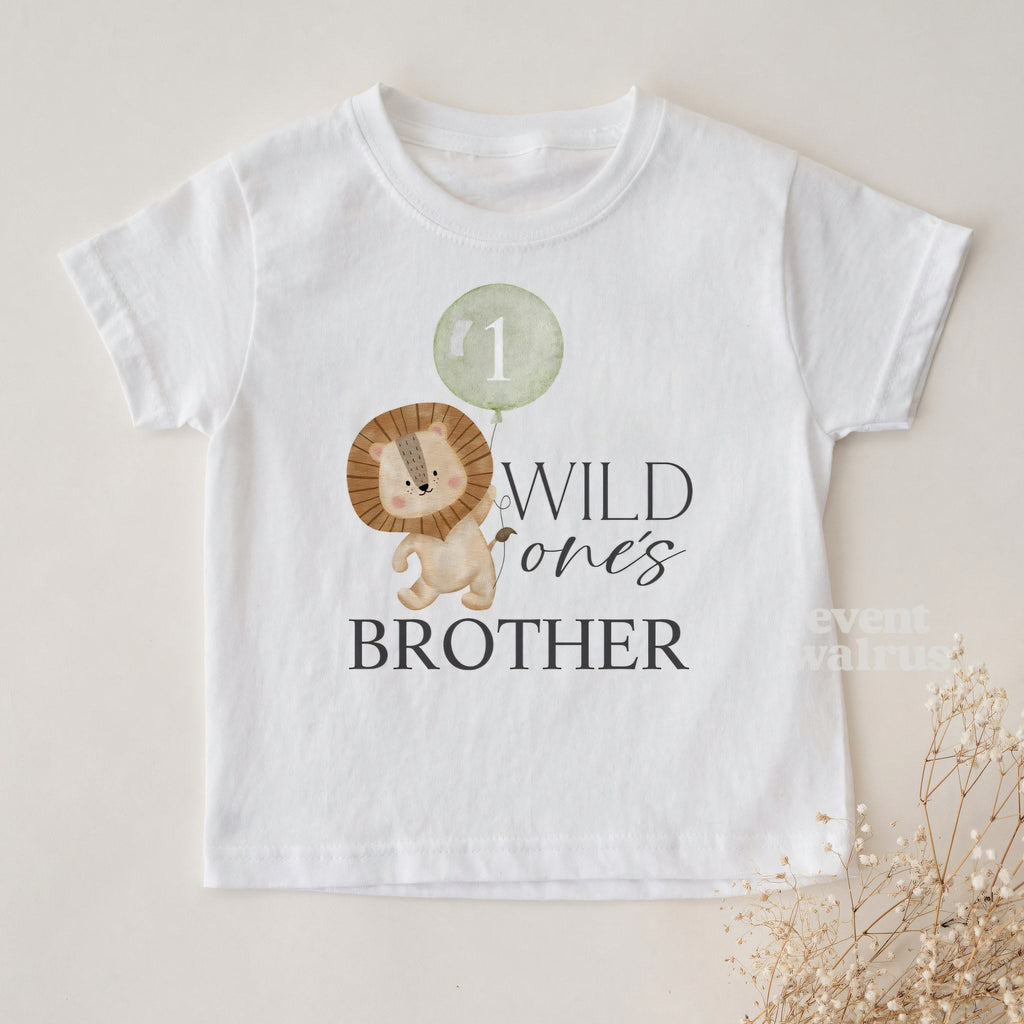 White Wild One's Brother toddler tee laid flat with sprigs of baby's breath.