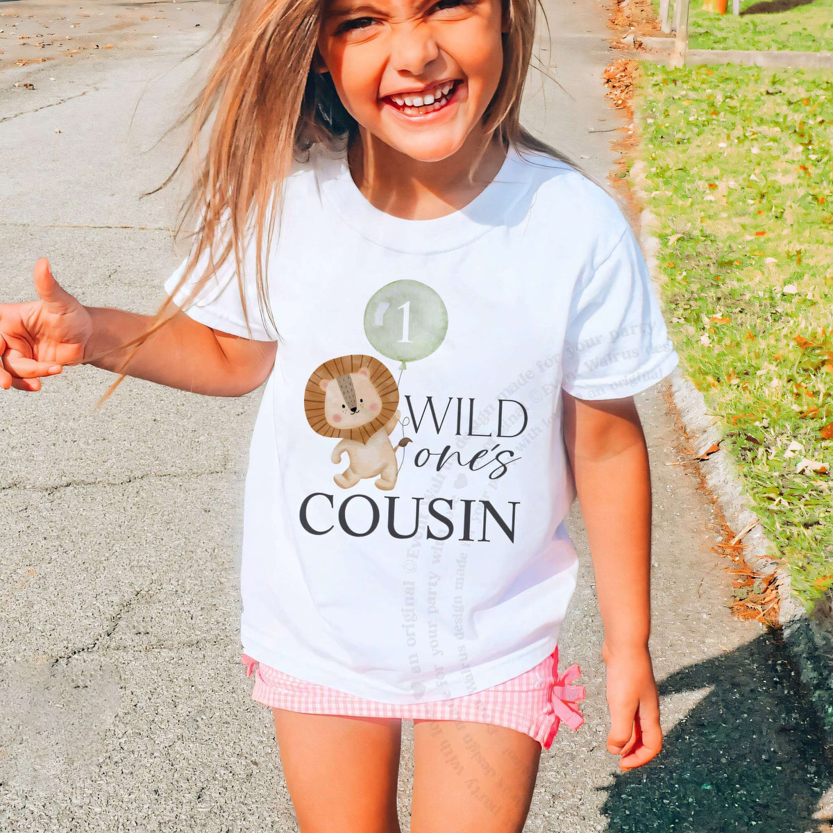 Laughing girl outdoors in a white Wild One's Cousin kids tee.