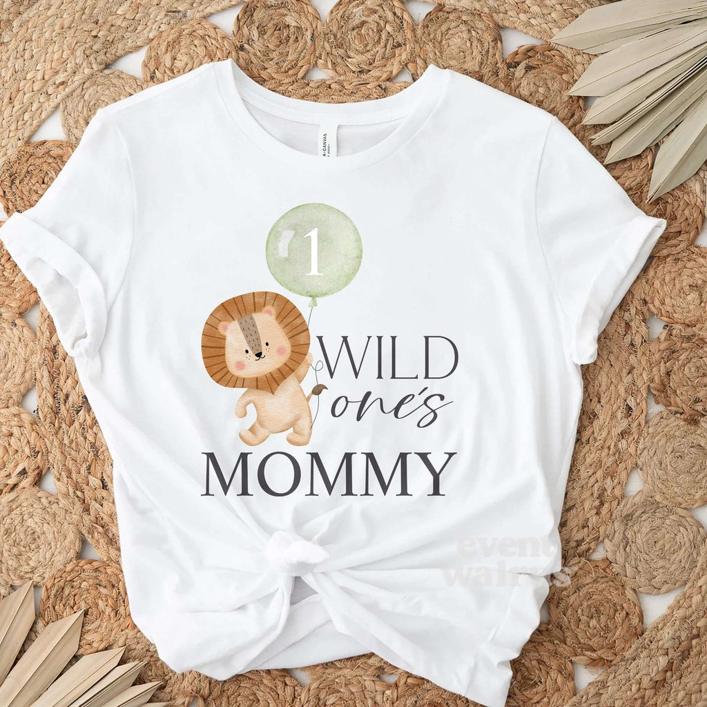 White Wild One's Mommy adult tee laid flat on a round jute rug with dried palm leaves.