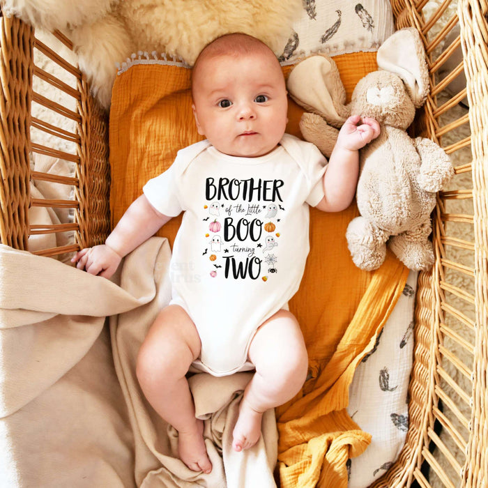 Baby in a wicker basket in a white Brother of the Little Boo bodysuit.