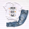 White Mom of the Little Boo Turning Two tee laid flat beside ripped jeans.