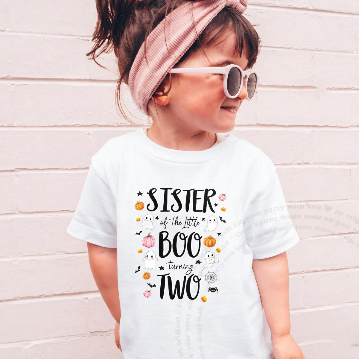 Girl in sunglasses and a pink headband wearing a white Sister of the Little Boo shirt.