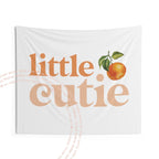 The little cutie backdrop hanging flat, showing the orange lettering and watercolor clementine.