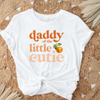 White Daddy of the Little Cutie tee knotted on a jute rug with dried palm leaves.
