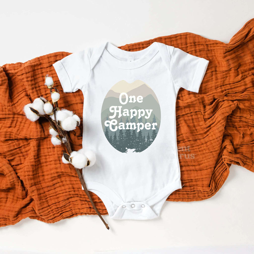 White One Happy Camper bodysuit on a rust blanket with cotton stems.