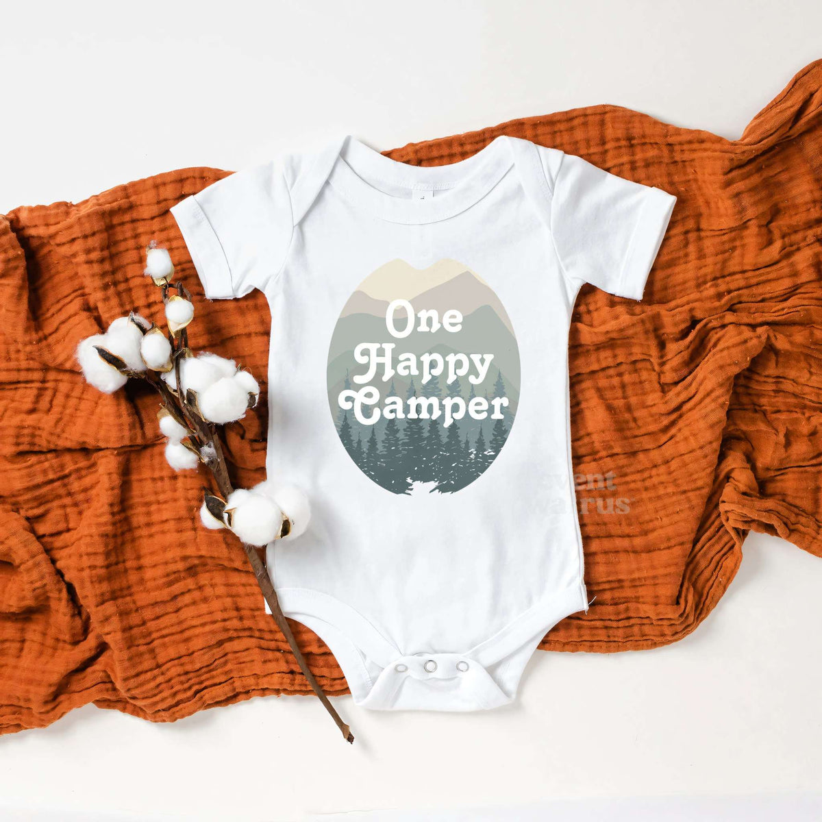 White One Happy Camper bodysuit on a rust blanket with cotton stems.