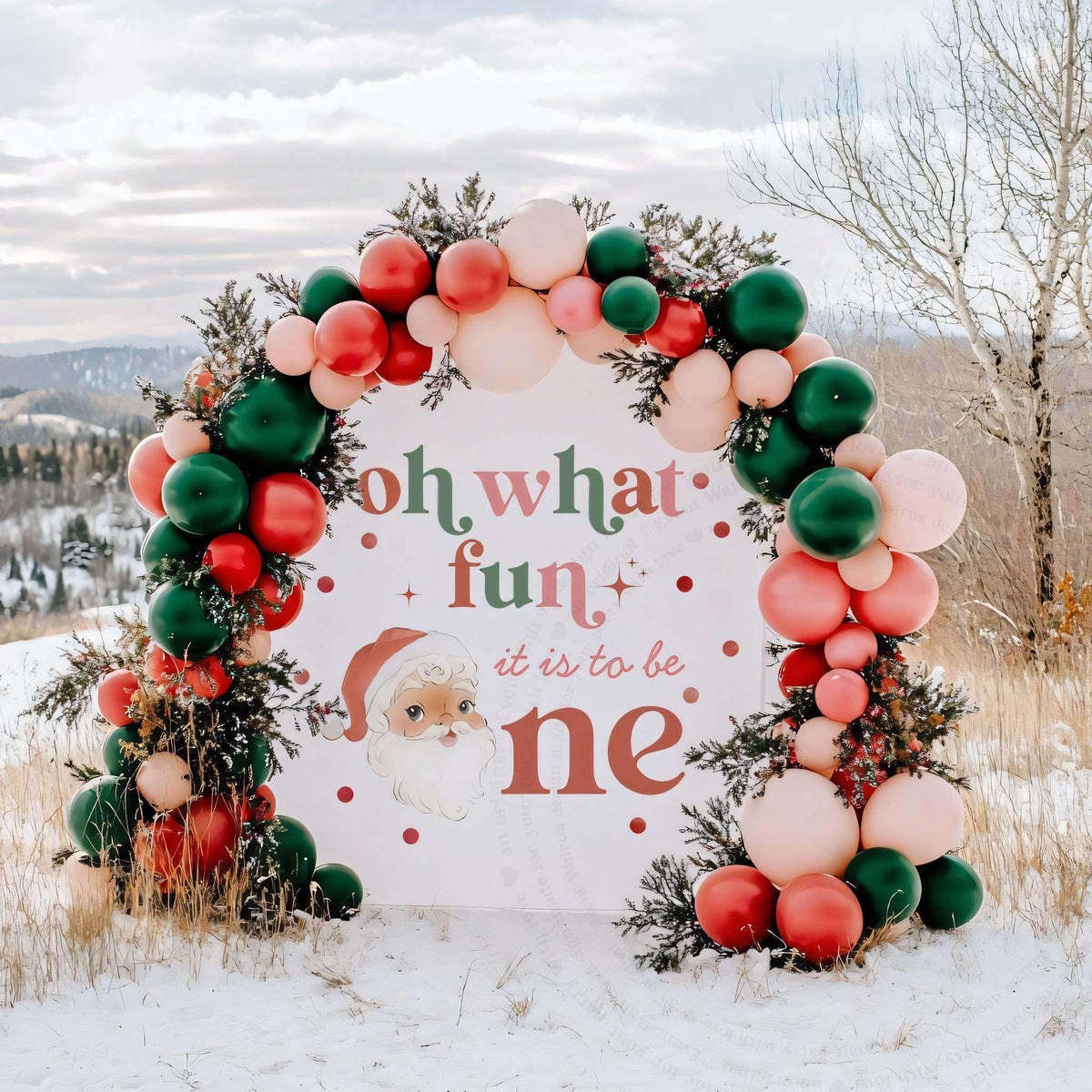 Oh what fun backdrop with a vintage Santa under a red, green and blush balloon arch in the snow.