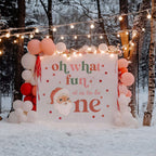 Oh what fun Christmas birthday backdrop between blush balloon columns under string lights in a winter forest.