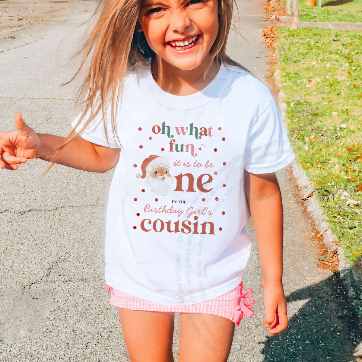 Laughing girl outdoors in a white Oh What Fun Cousin kids tee.