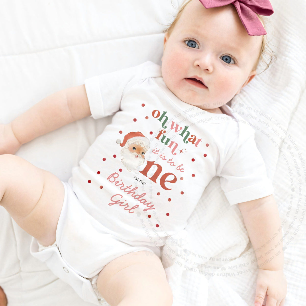 Baby girl with a pink bow lying in a white Oh What Fun Birthday Girl bodysuit.