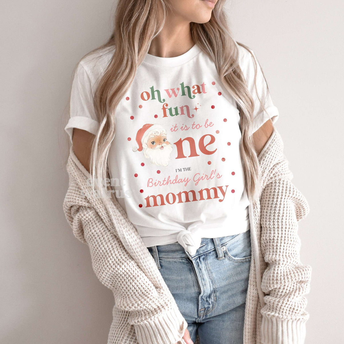 Woman in a knit cardigan wearing a white Oh What Fun It Is to Be One Mommy shirt.
