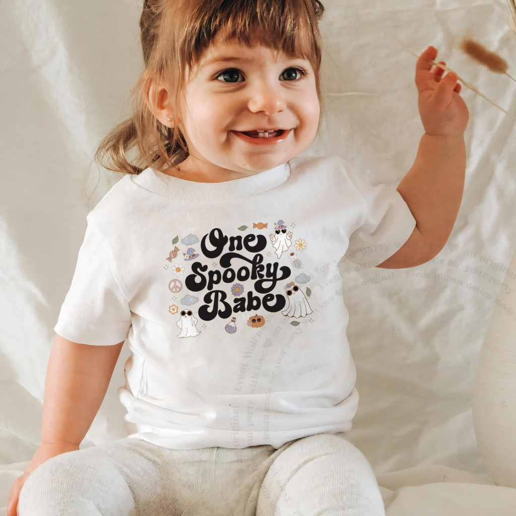 Laughing baby girl in a white One Spooky Babe baby tee.