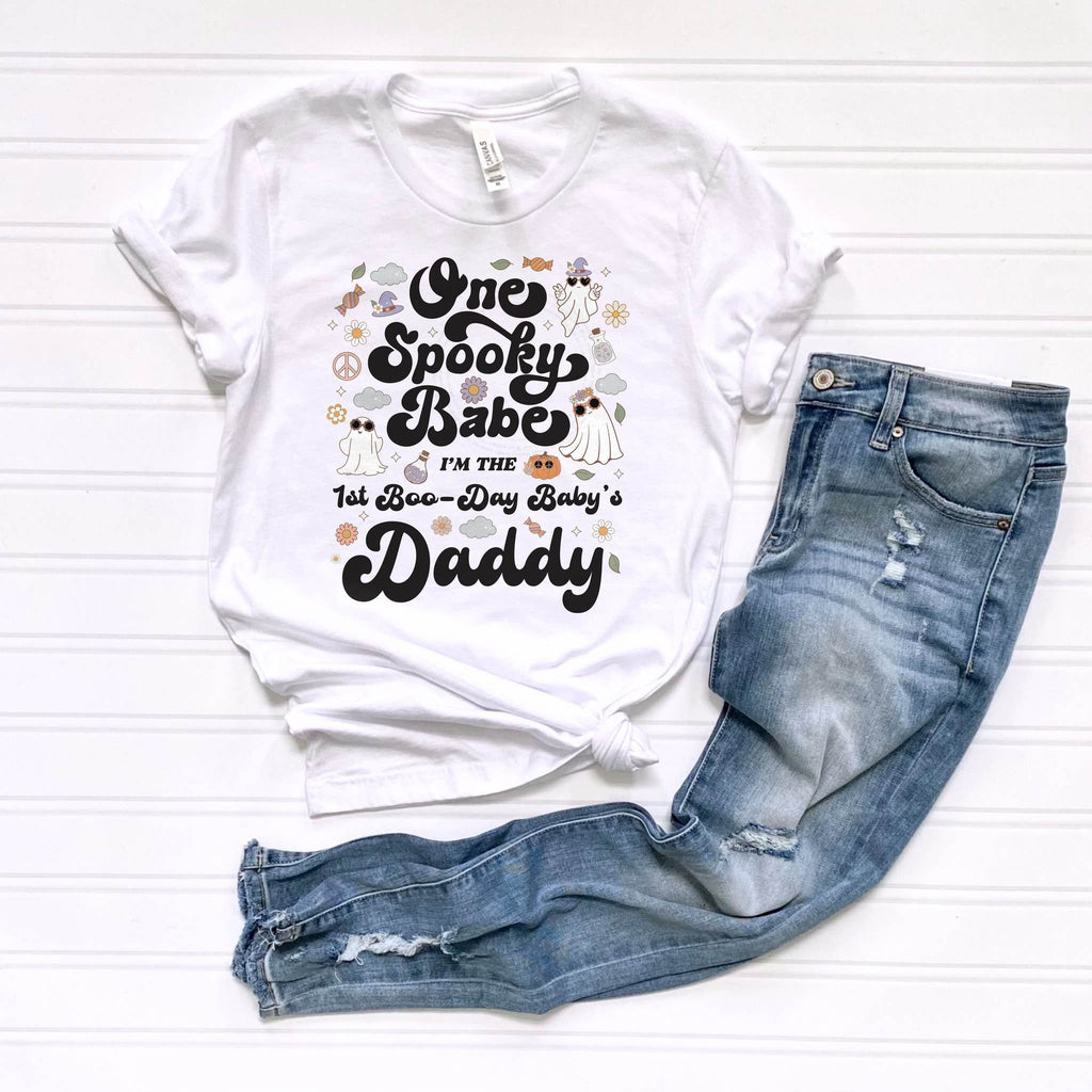White One Spooky Babe Daddy tee laid flat beside jeans.