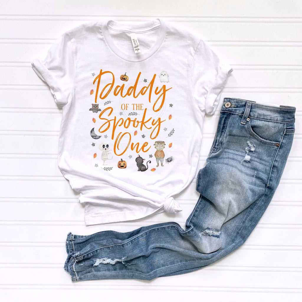 White Daddy of the Spooky One tee laid flat beside jeans.