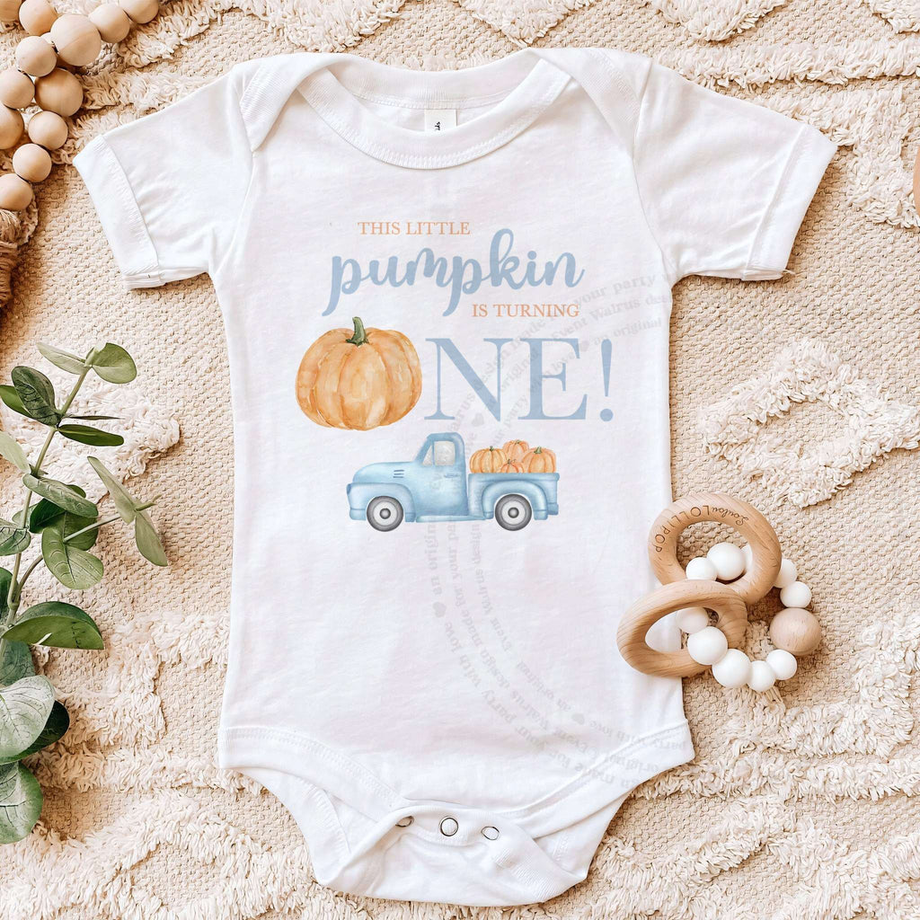 White Little Pumpkin bodysuit on a beige blanket with a wooden teether.