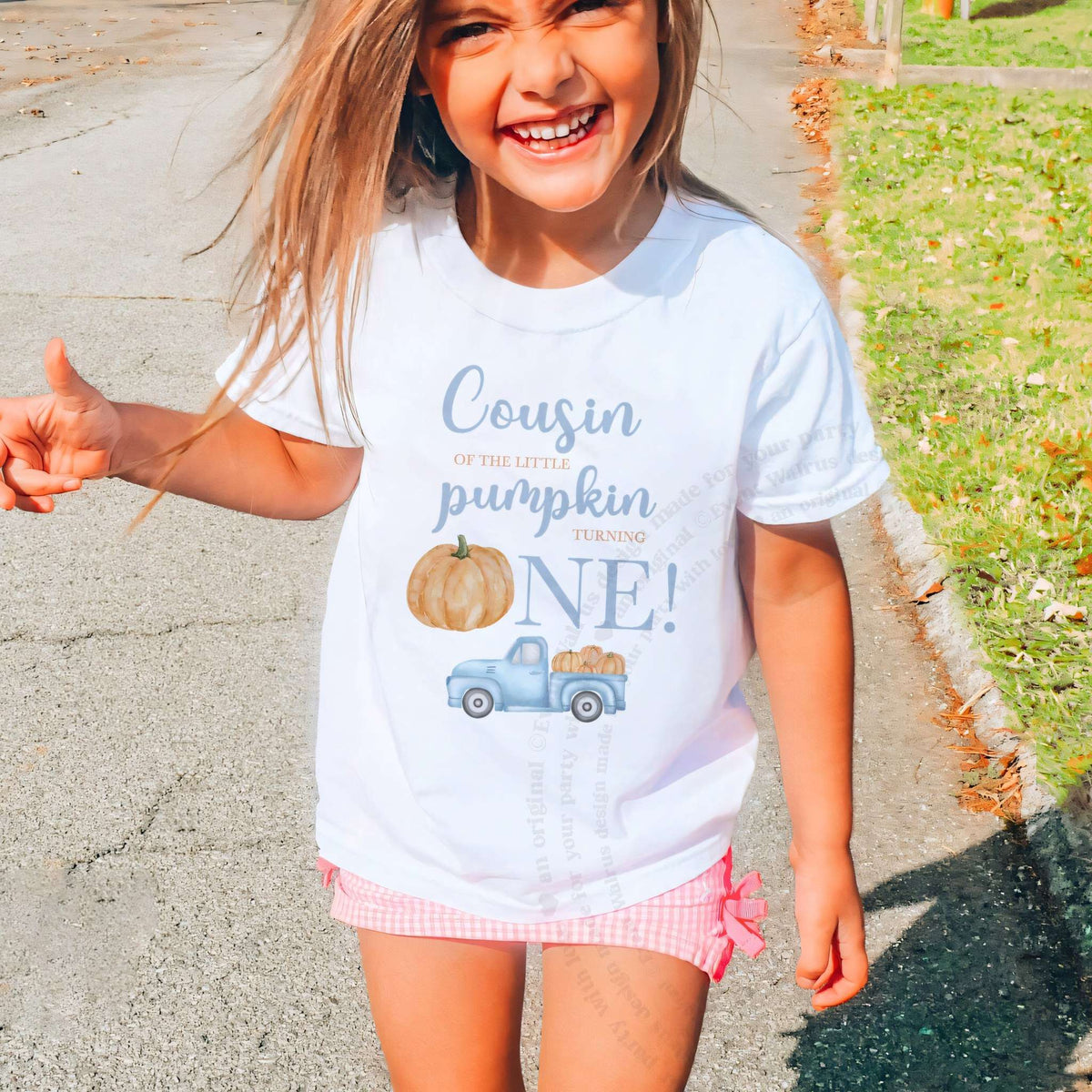 Laughing girl outdoors in a white Cousin of the Little Pumpkin kids tee.