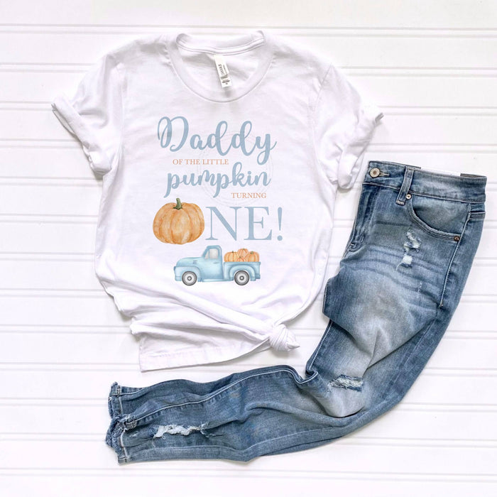 White Daddy of the Little Pumpkin tee laid flat beside jeans.