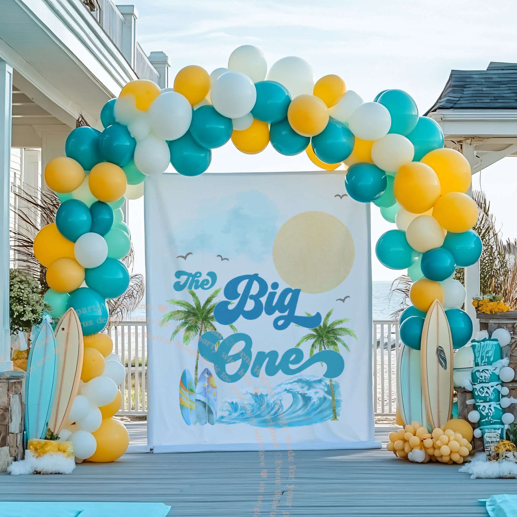 Palm tree surf backdrop in a teal and yellow balloon arch with surfboards.