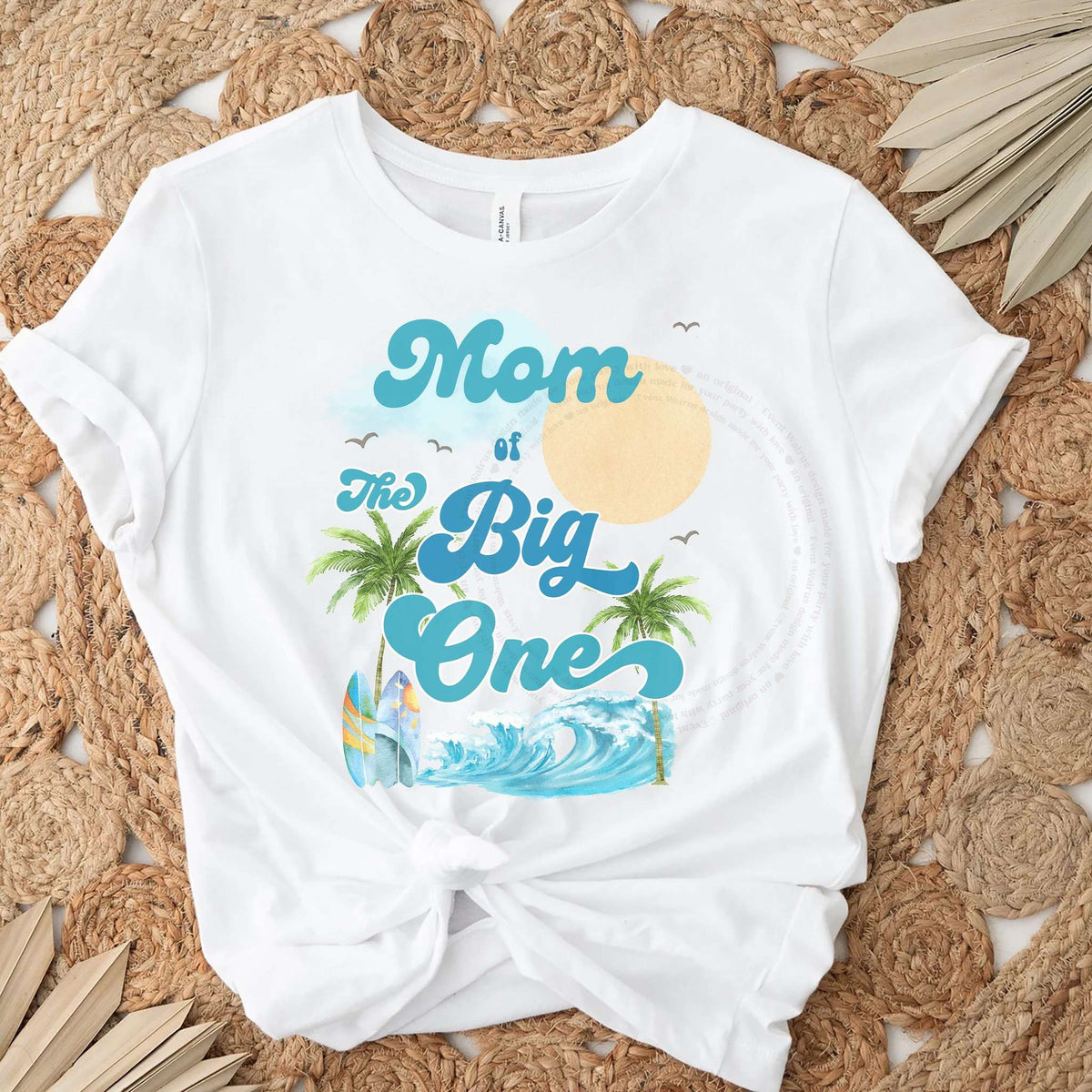White Mom of The Big One palm tree tee knotted on a jute rug.