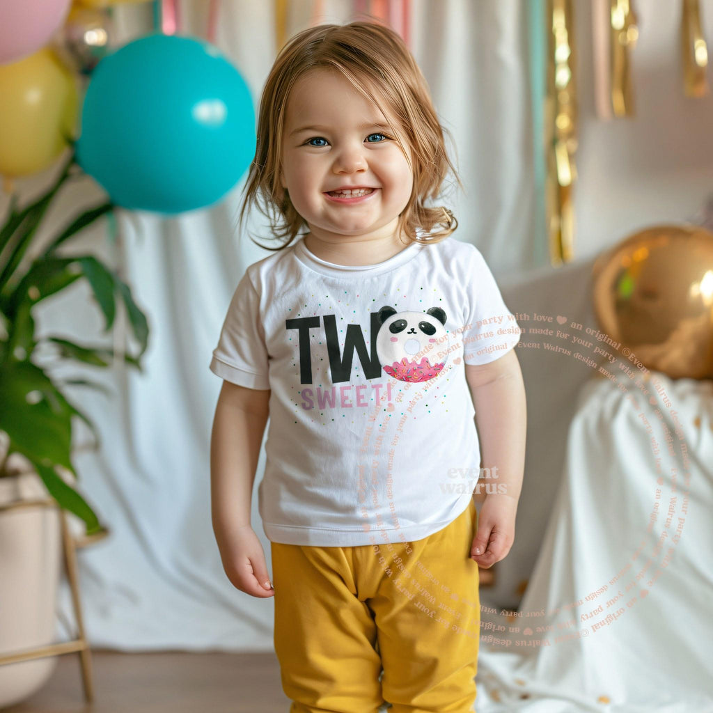 Smiling toddler girl at a party in a white Two Sweet panda tee.