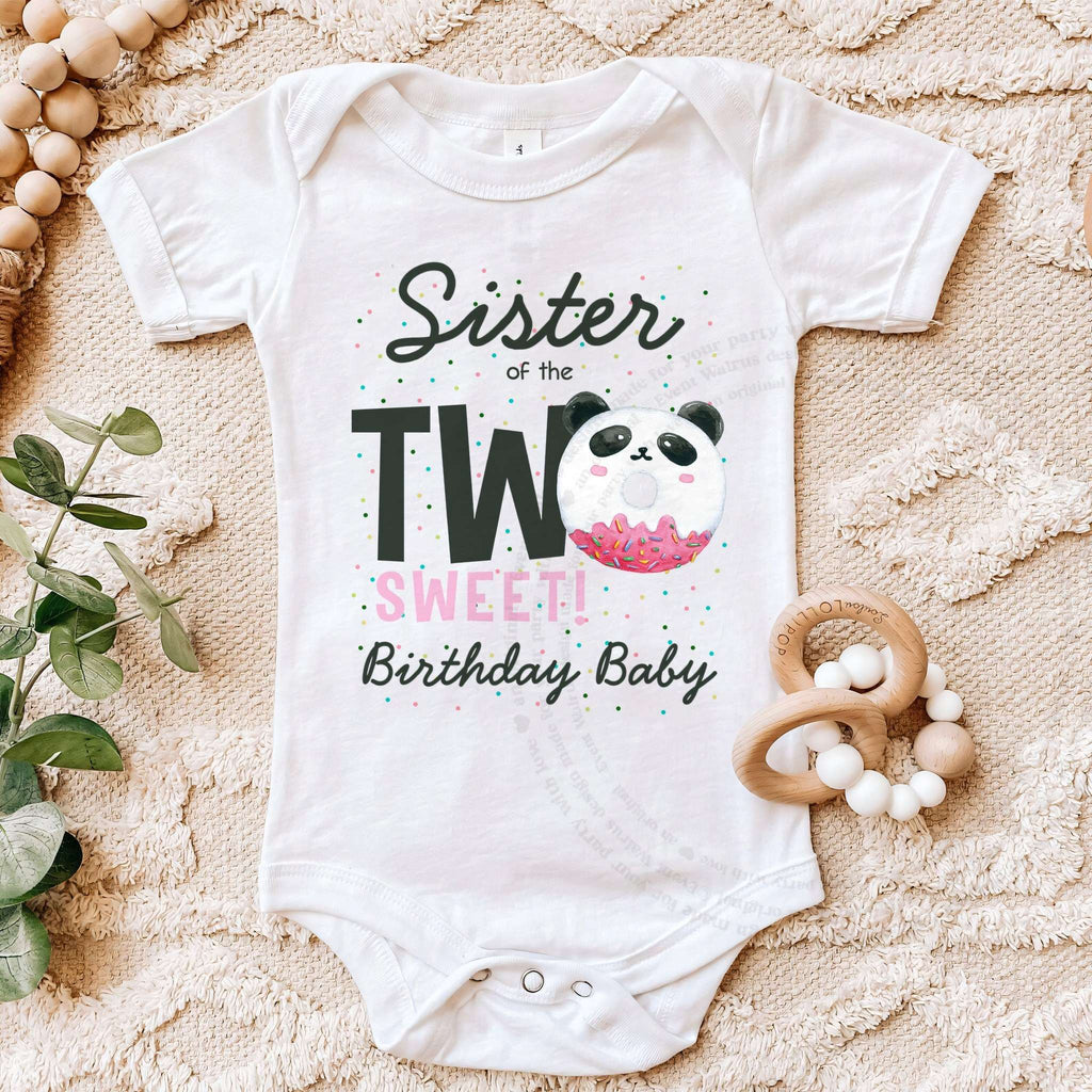 White Sister of the Two Sweet panda bodysuit on a beige blanket with a wooden teether.