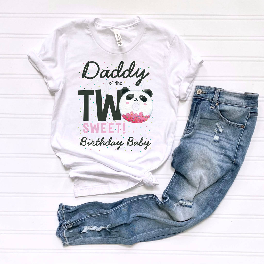 White Daddy of the Two Sweet panda tee laid flat beside jeans.