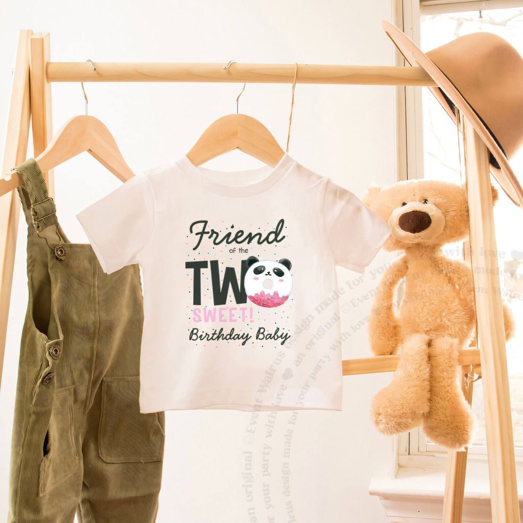 White Friend of the Two Sweet toddler tee on a wooden clothes rack beside a teddy bear.