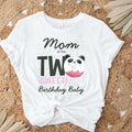 White Mom of the Two Sweet panda donut tee laid flat on a jute rug with dried palm leaves.
