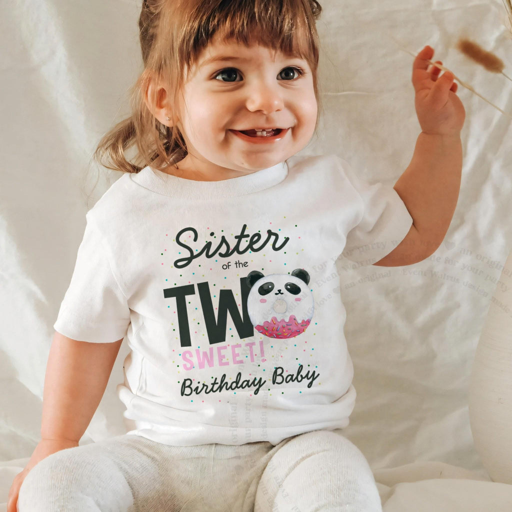 Laughing baby girl in a white Sister of the Two Sweet baby tee.