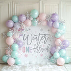 Pastel rose winter onederland backdrop framed by mint, lilac and pink balloons with silver snowflakes.