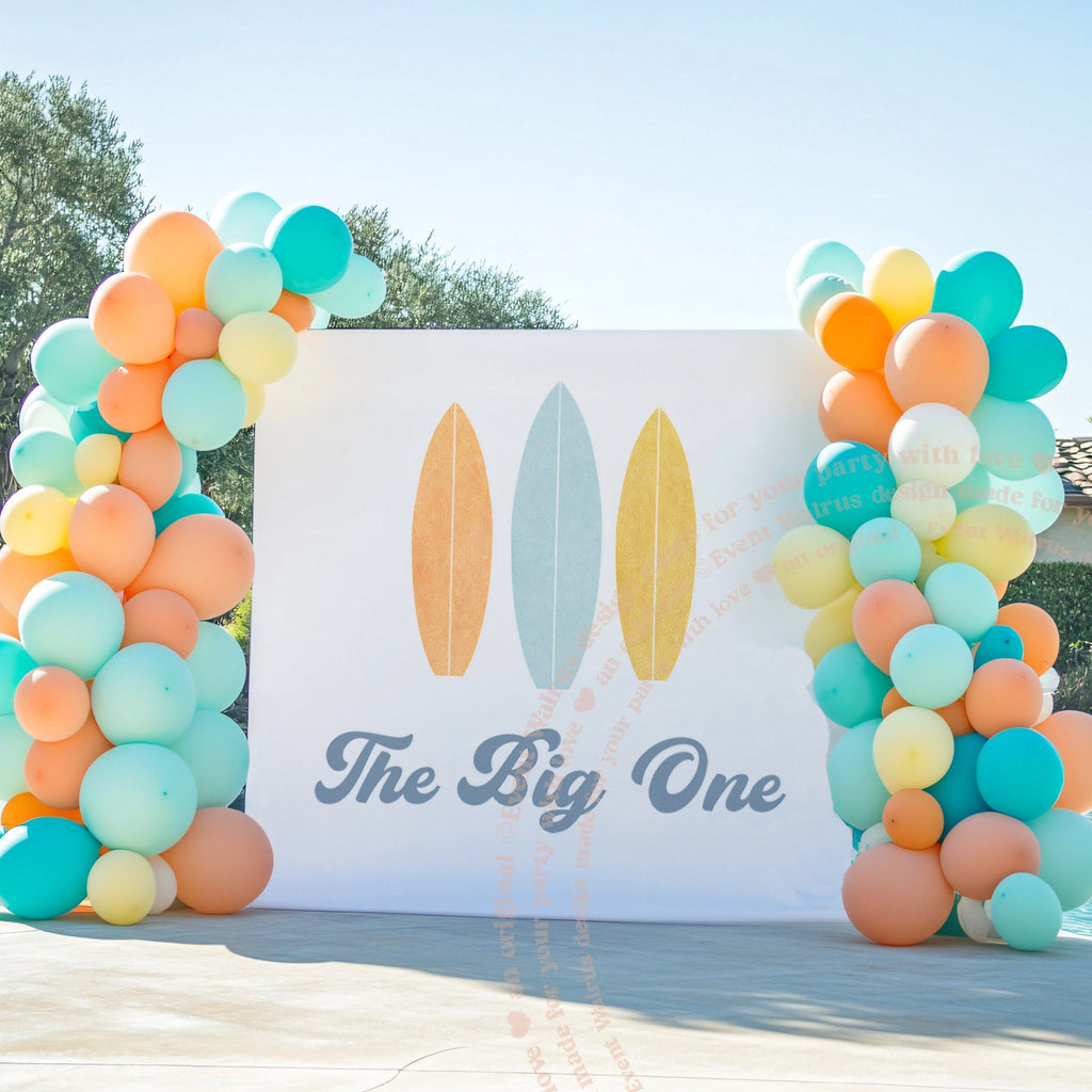Pastel surfboard backdrop by a pool between orange, aqua and yellow balloon columns.
