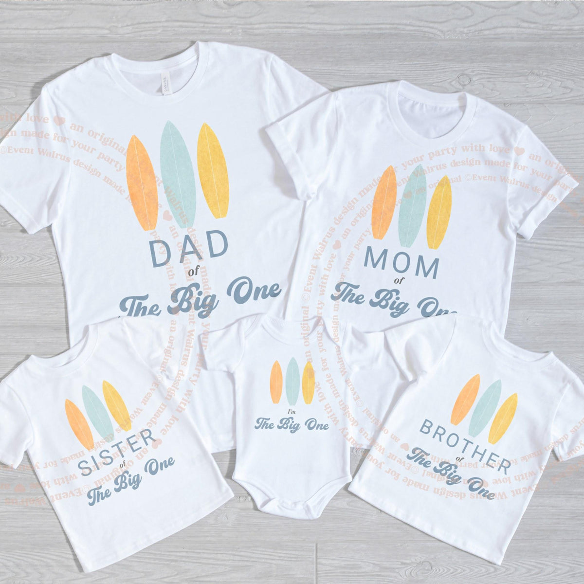 White I'm The Big One bodysuit laid flat with the family's surfboard shirts.