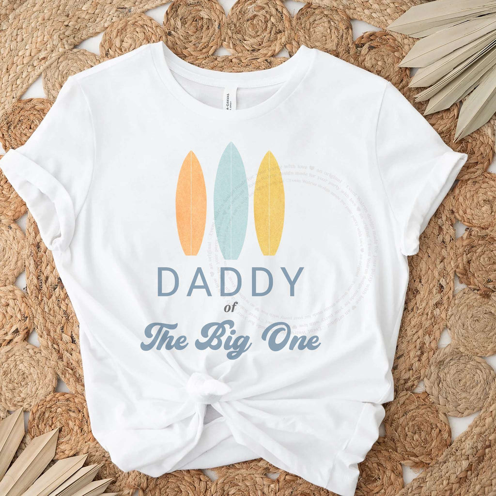 White Daddy of The Big One tee with three pastel surfboards, knotted on a jute rug.