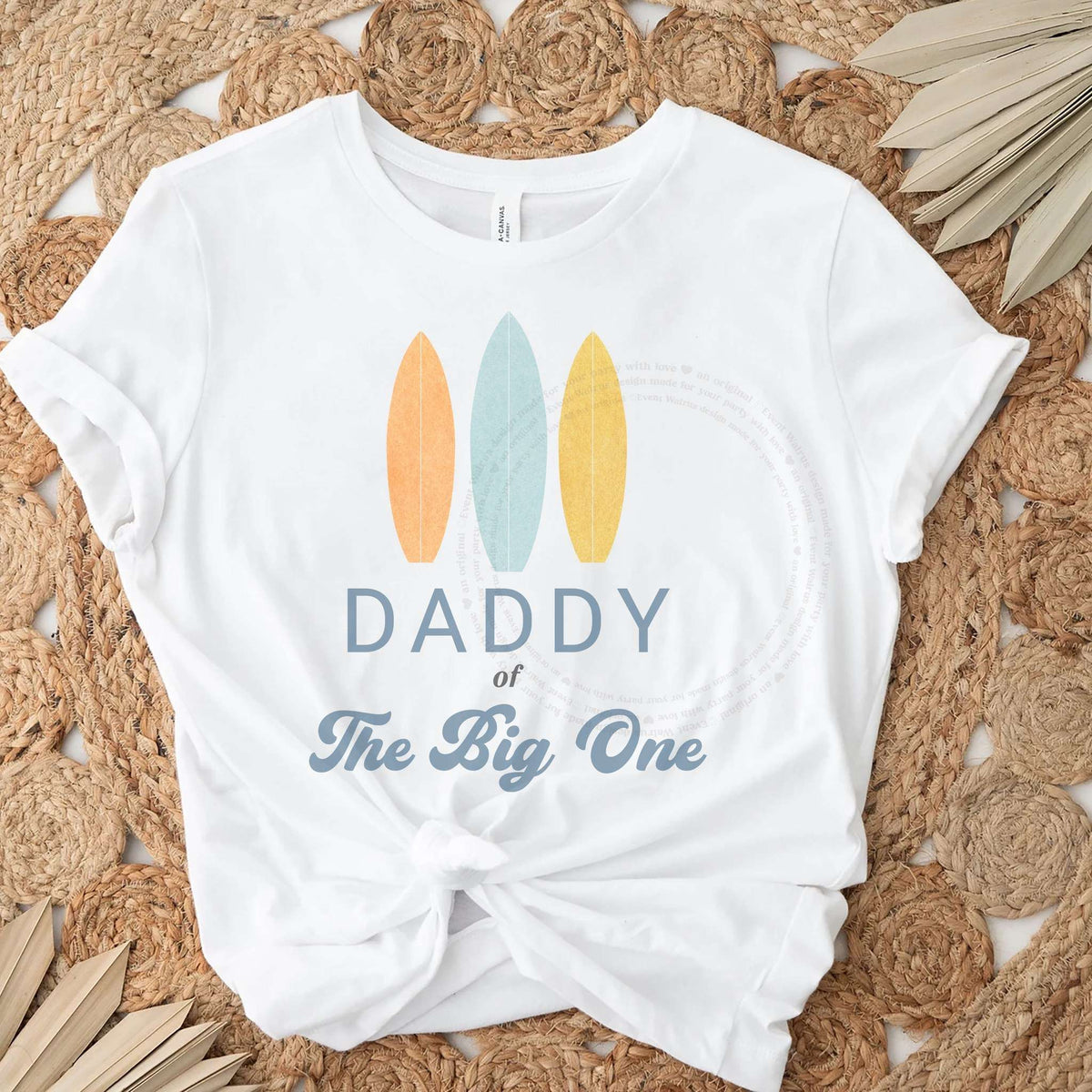 White Daddy of The Big One tee with three pastel surfboards, knotted on a jute rug.
