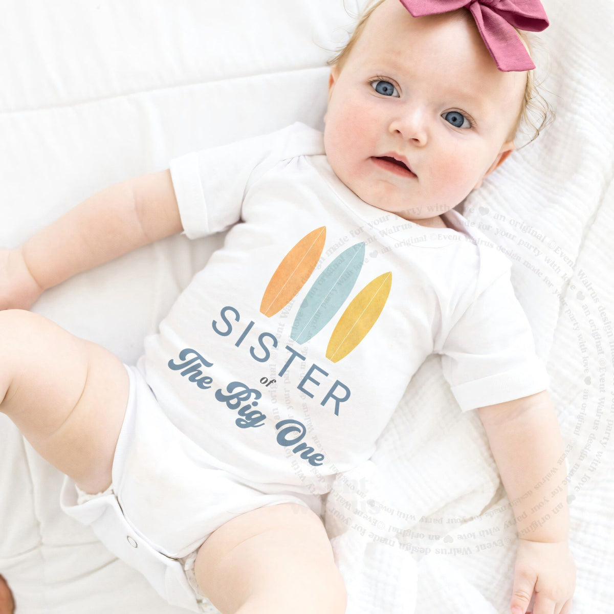 Baby girl with a pink bow in a white Sister of The Big One bodysuit.