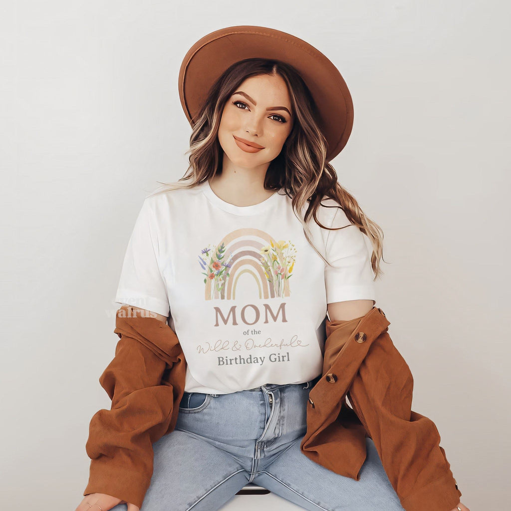 Woman in a brown hat wearing a white Mom shirt with a wildflower rainbow.