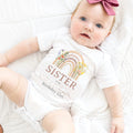 Baby girl with a pink bow in a white Sister of the Wild and Onederful Birthday Girl bodysuit.