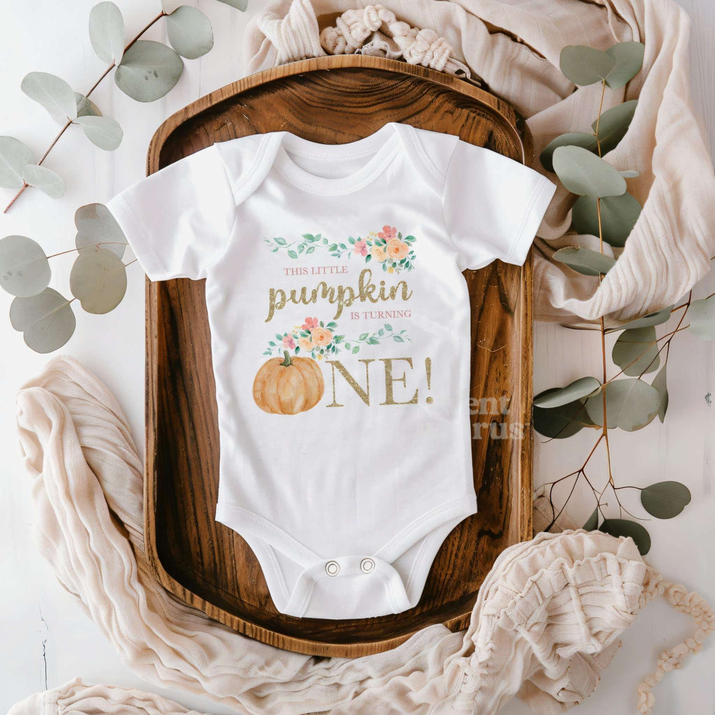 White Little Pumpkin bodysuit on a wooden tray with eucalyptus and a knit blanket.